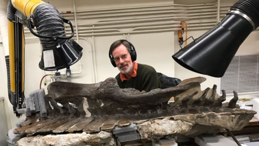 Alan Munro, a graduate Student at George Mason University, works on a dinosaur fossil in the Museum's Fossil Lab.picture